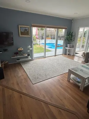 a living room with a view of a pool at Family Home in West Beach, Blouberg in Cape Town