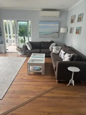 a living room with a couch and a table at Family Home in West Beach, Blouberg in Cape Town
