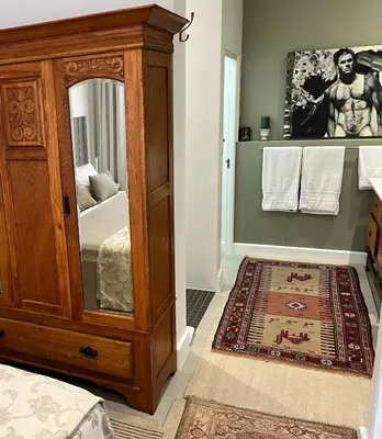 a bedroom with a wooden dresser and a mirror at Somerset West All Stay 3 in Somerset West