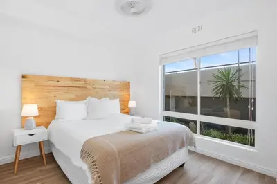 a bedroom with a bed and a large window at Leisure Bay 117 in Cape Town
