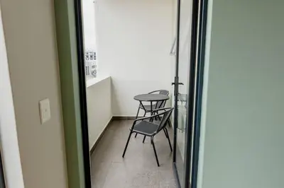 a chair and a table in a room with a window at Sunny Beach Apartment with Sea & Mountain Views in Cape Town