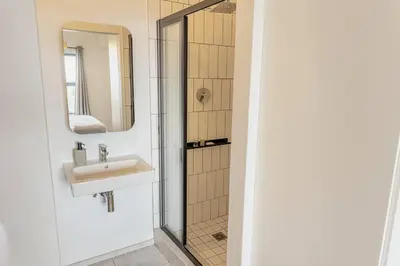 a bathroom with a sink and a shower at Sunny Beach Apartment with Sea & Mountain Views in Cape Town