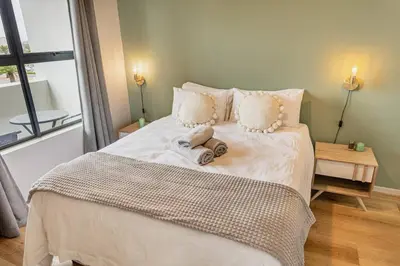 a bedroom with a bed with a towel on it at Sunny Beach Apartment with Sea & Mountain Views in Cape Town