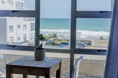 a room with a table and a view of the ocean at Beach & Sea View Facing Apartment Japanese Styled in Cape Town