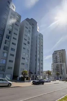 two tall buildings with cars parked in front of them at Beach & Sea View Facing Apartment Japanese Styled in Cape Town