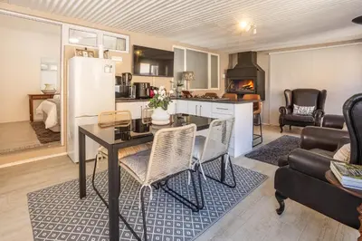 a kitchen and living room with a table and a refrigerator at Inn 201 in Hermanus