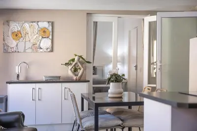 a kitchen and dining room with a table and chairs at Inn 201 in Hermanus