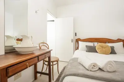 a bedroom with a bed and a desk with a bowl on it at Inn 201 in Hermanus