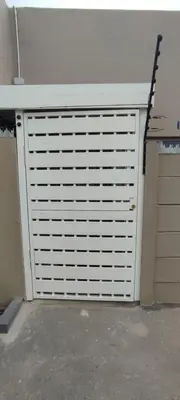 a garage door with white panels on the side of a building at Lasai Accommodation in Worcester