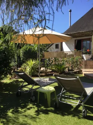 a couple of chairs and an umbrella in a yard at Roundhouse Guesthouse in Franschhoek