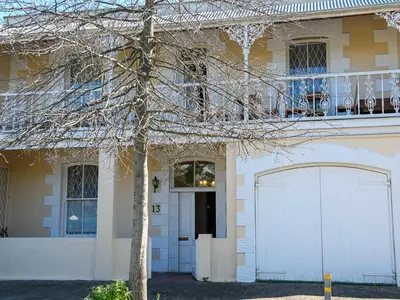 a white house with a white garage door and a tree at Petites Bulles Lodge in Stellenbosch
