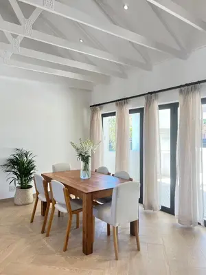 a dining room with a wooden table and chairs at Chasselas Self Catering in Cape Town