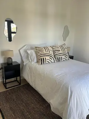 a white bed with pillows on it in a bedroom at Chasselas Self Catering in Cape Town