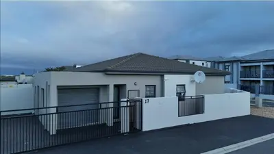 a white house with a black fence at Rachel`s Guest House - Cape Town in Cape Town