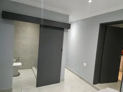 a bathroom with a toilet and a black door at Rachel`s Guest House - Cape Town in Cape Town