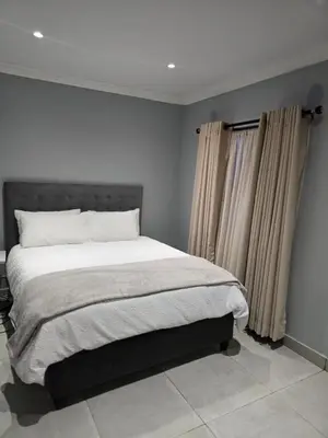 a bedroom with a large bed and curtains at Rachel`s Guest House - Cape Town in Cape Town