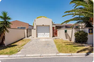 a house with a driveway with a garage at A Room with private Entrance in Cape Town