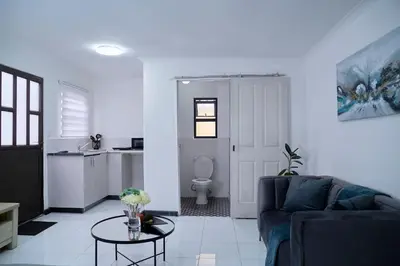 a living room with a couch and a table at Blomtuin Sleep and go room in Cape Town