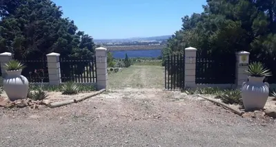 a black fence with white vases in front of a yard at Piece of Paradise in Cape Town