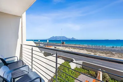 a balcony with a view of the beach and the ocean at 9 On The Waves in Cape Town