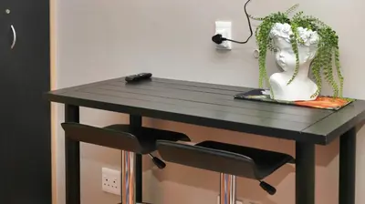 a black table with a chair and a vase on it at Royal Beauty in Paarl