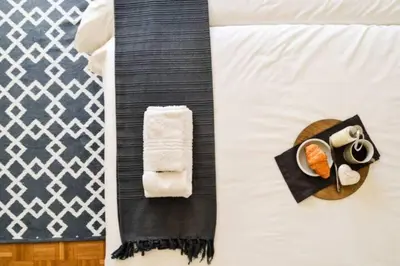 a bed with a plate of sushi and a towel at Olive Grove on Provident in Cape Town