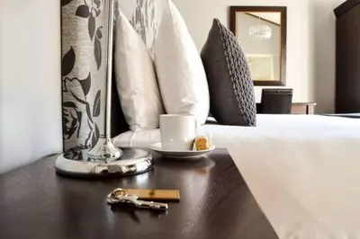 a bedroom with a bed with a coffee cup on a table at Olive Grove on Provident in Cape Town