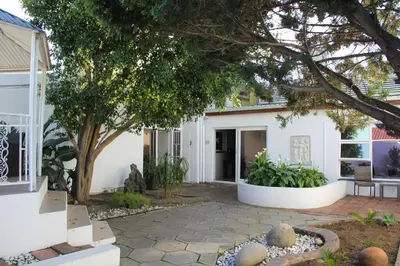 a home with a tree and a patio at Olive Grove on Provident in Cape Town