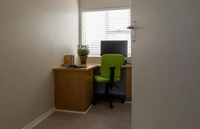 an office with a green chair sitting at a desk at Twin Gables, centrally located 2 bedroom apartment in Hermanus