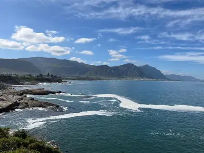 a body of water with mountains in the background at Twin Gables, centrally located 2 bedroom apartment in Hermanus