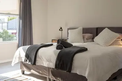 a bedroom with a bed with black towels on it at Twin Gables, centrally located 2 bedroom apartment in Hermanus