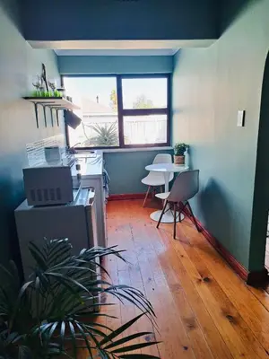 a room with a kitchen with a table and a dining room at Rondebosch Cottage in Cape Town