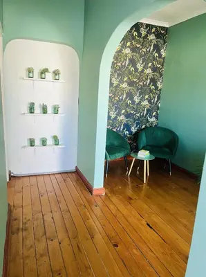 two green chairs and a table in a room at Rondebosch Cottage in Cape Town