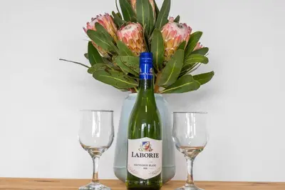a bottle of wine and two glasses on a table at Beach Break Two in Cape Town