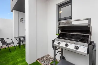 a kitchen with a stove and a window at Beach Break Two in Cape Town