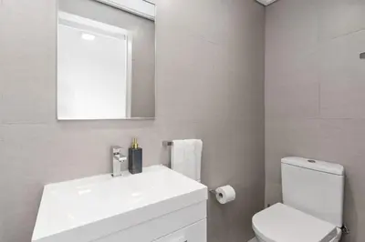 a bathroom with a sink and a toilet and a mirror at Beach Break Two in Cape Town