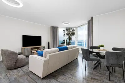 a living room with a couch and a tv and a table at ZenDen Destinations' Tidal Tranquillity in Cape Town