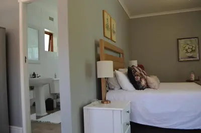 a bedroom with a bed and a sink and a mirror at Gatsby Suite, with pool in quiet area, close to town in Stellenbosch