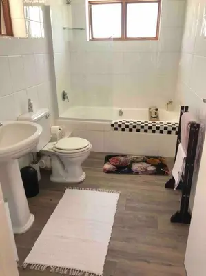 a bathroom with a toilet and a sink and a tub at Gatsby Suite, with pool in quiet area, close to town in Stellenbosch