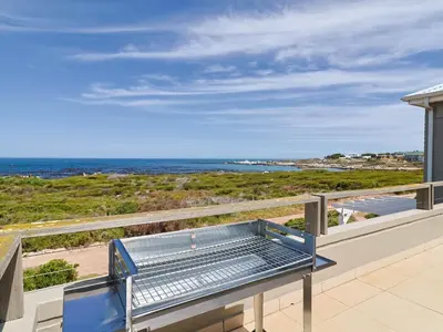 a balcony with a view of the ocean at Penguin View in Bettyʼs Bay