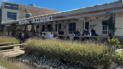a group of people sitting outside of a building at Listening Wind Self-Catering accommodation in Bettyʼs Bay