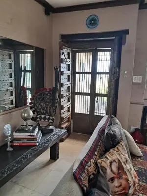 a living room with a couch and a table with books at Listening Wind Self-Catering accommodation in Bettyʼs Bay
