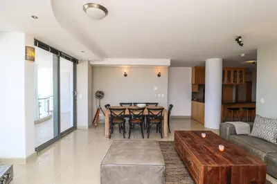 a living room with a table and a couch at 1402 Hibernian Towers Luxury Self Catering Apartment Strand Western Cape South Africa in Cape Town