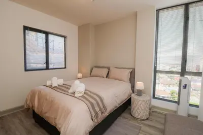 a bedroom with a bed with two white towels on it at 1402 Hibernian Towers Luxury Self Catering Apartment Strand Western Cape South Africa in Cape Town