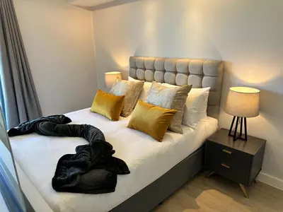 a bedroom with a large bed with yellow pillows at The Westwood Deluxe Studio in Cape Town