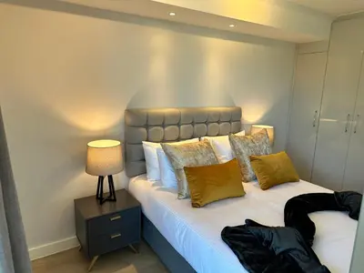 a bedroom with a large bed with yellow pillows at The Westwood Deluxe Studio in Cape Town