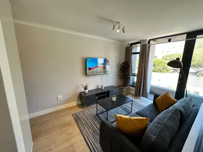 a living room with a couch and a table at The Westwood Deluxe Studio in Cape Town
