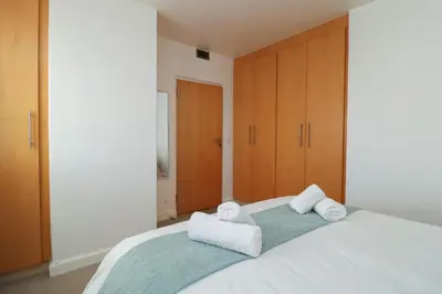 a bedroom with a large bed with towels on it at 1401 Hibernian Towers Luxury Self Catering Apartment Strand Western Cape South Africa in Cape Town