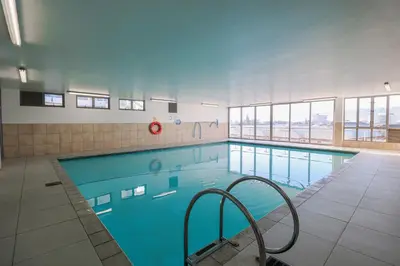 a large swimming pool in a building at 1401 Hibernian Towers Luxury Self Catering Apartment Strand Western Cape South Africa in Cape Town