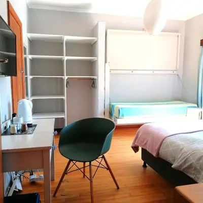 a bedroom with a desk and a chair and a bed at Aloha Lodge in Cape Town